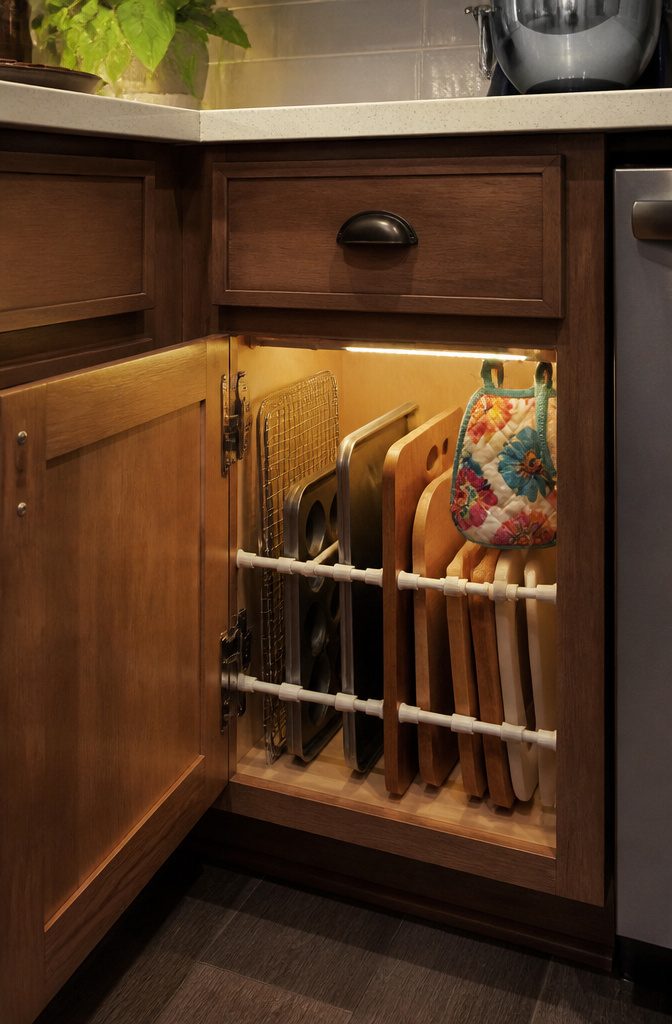 20 Clever Home Storage Ideas for Every Room in 2026 11 Baking sheets organized vertically with tension rods in a kitchen cabinet.