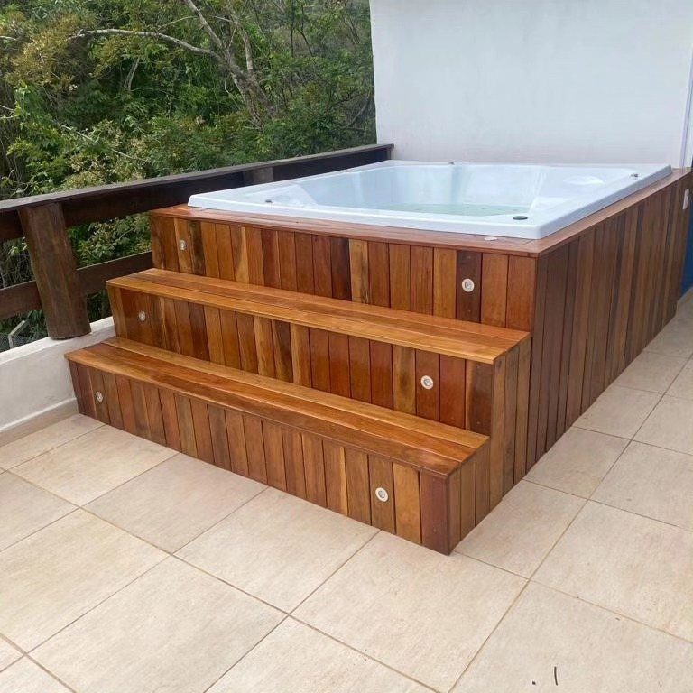 7 Covered Hot Tub Ideas for Backyard Privacy and Style (2026) 5 Wooden steps built into a hot tub enclosure on a tiled outdoor balcony.