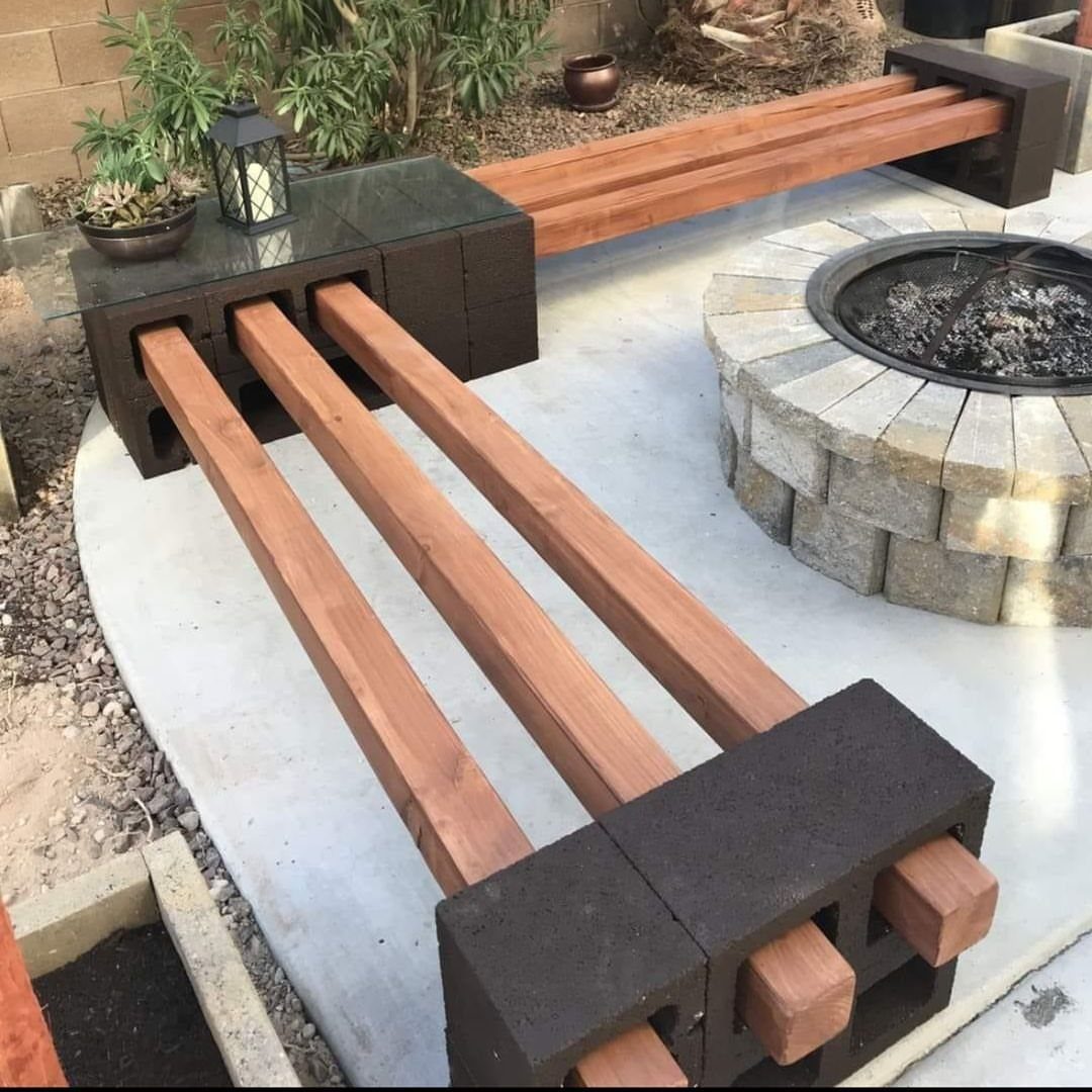 DIY Garden Bench: 8 Plans from Classic Backrests to Cinder Block Builds 8 A handmade garden bench constructed from dark cinder blocks and long wooden slats on a patio.