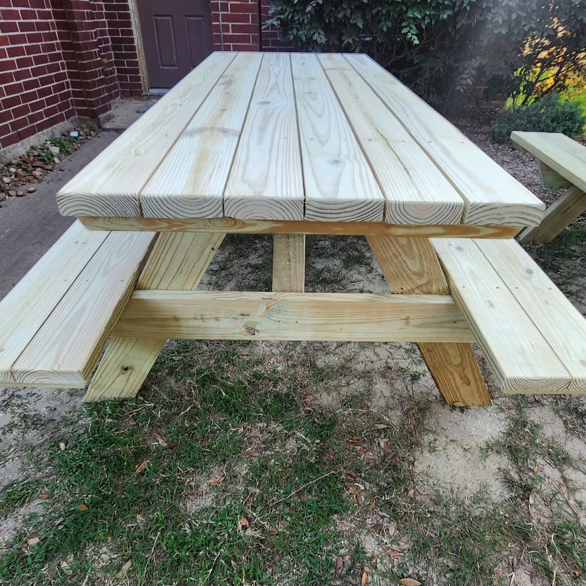 9 DIY Outdoor Furniture Ideas: Pallet Tables to Adirondack Chairs 5 A light wood picnic table with attached benches on a grassy outdoor area.