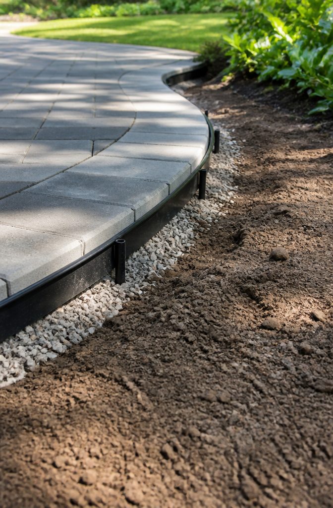 Plastic edging placed around the perimeter of a paver patio.
