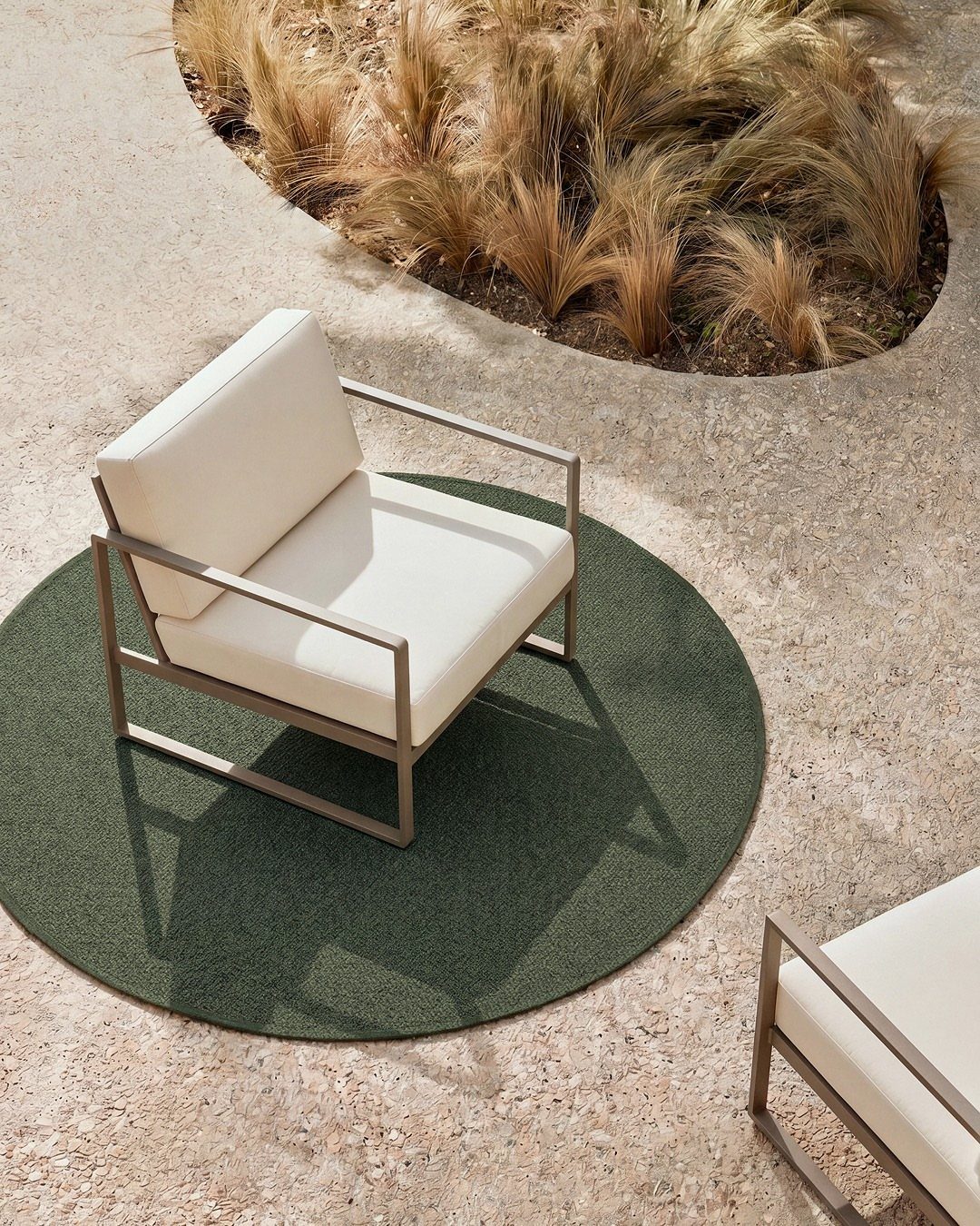 7 Easy DIY Patio Ideas With Paver Floors, Pallets and Gravel 6 Modern white outdoor armchairs on a circular green rug atop a concrete patio surface.
