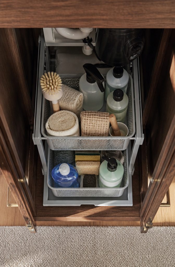 Cleaning supplies arranged for easy access in an under-sink cabinet.