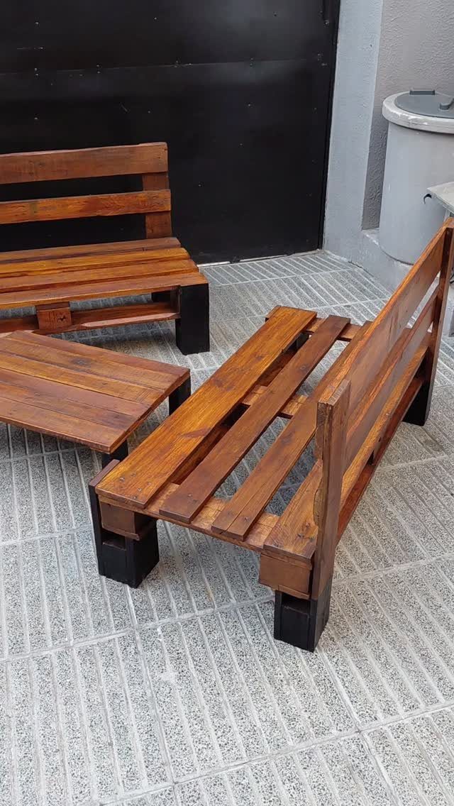Wooden pallet benches and a matching low coffee table on a tiled patio.