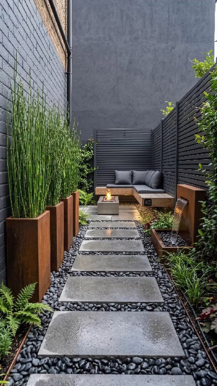 Stone pavers set in black pebbles lead to a modern seating area with a fire pit.